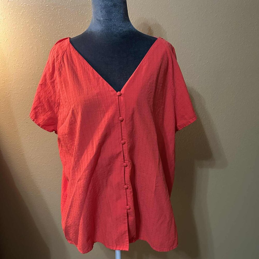 Ladies red short sleeve blouse with fabric button detail.